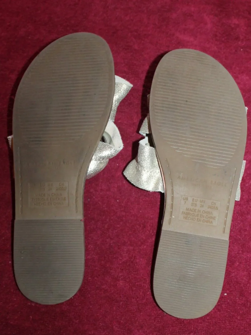 American Eagle Outfitters metallic gold double-strap ruffle slide sandals.